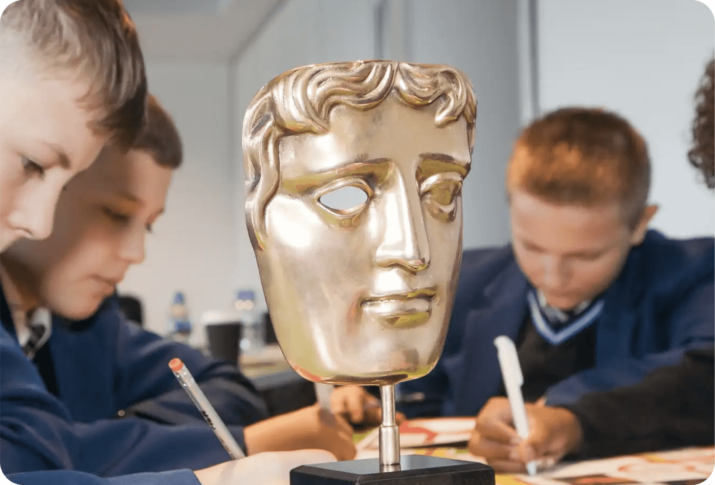 BAFTA award on a desk with school children